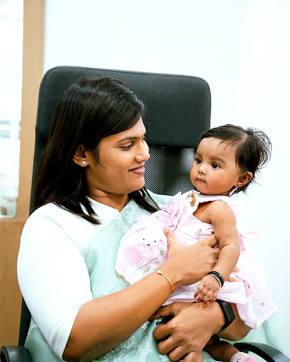Dr. Archana holding a smiling baby girl at Pinnacle Fertility, Nizamabad