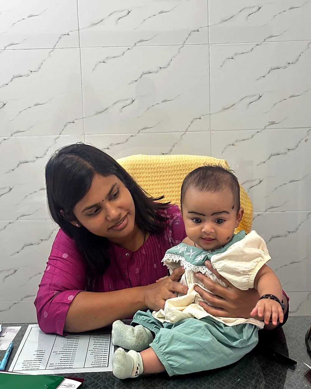 Dr. Archana cradling a baby during a follow-up visit