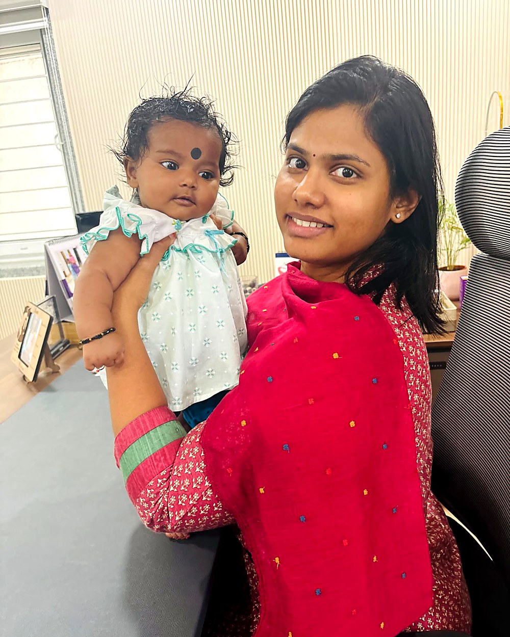 Dr. Archana holding a newborn baby at the clinic